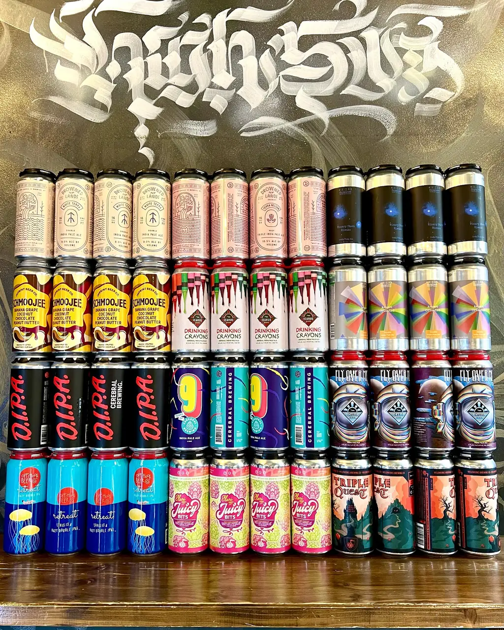 Wall of craft beer cans under the hand-painted HIGH FIVE calligraphy mural